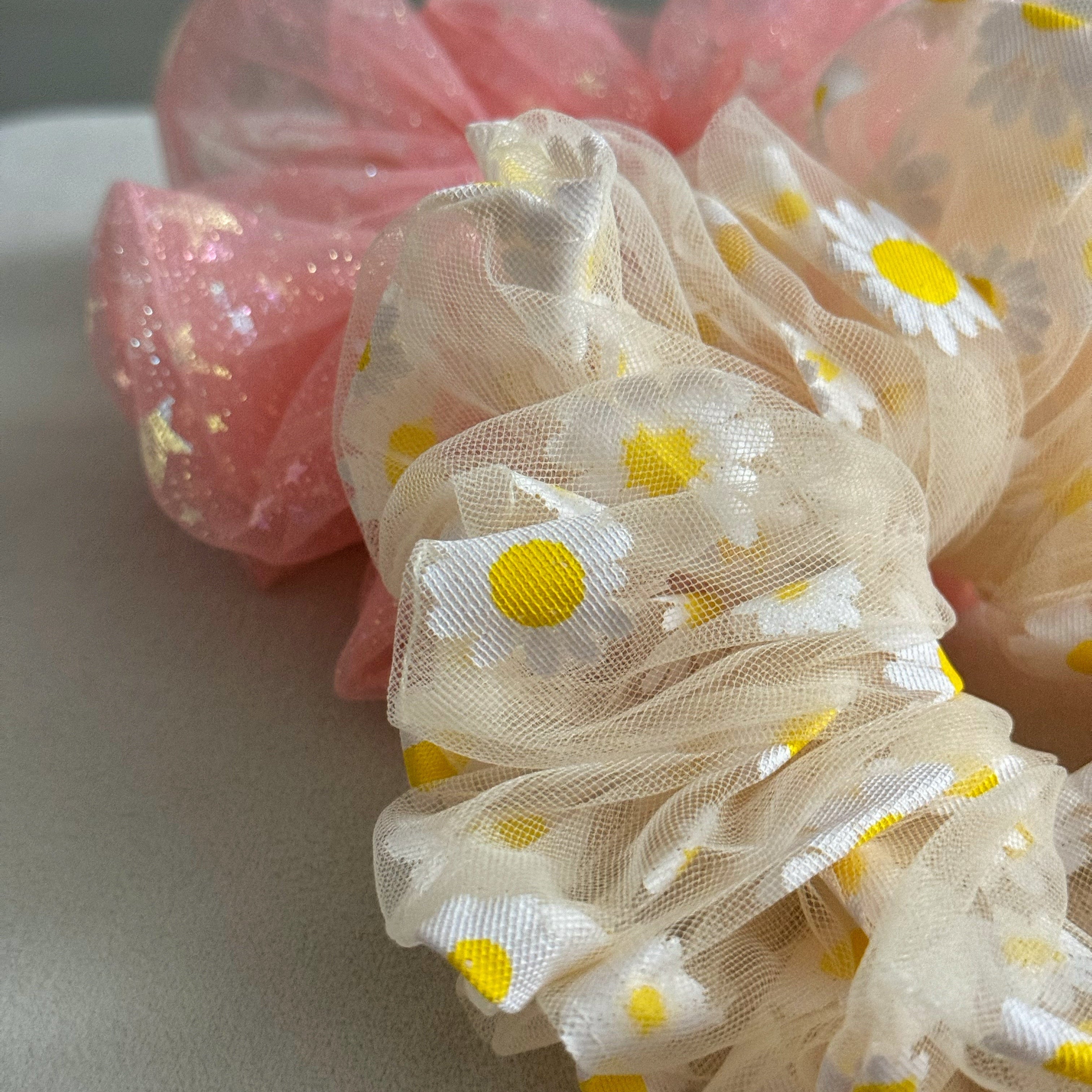 yellow and pink sheer scrunchies with yellow floral patterns on a light gray background