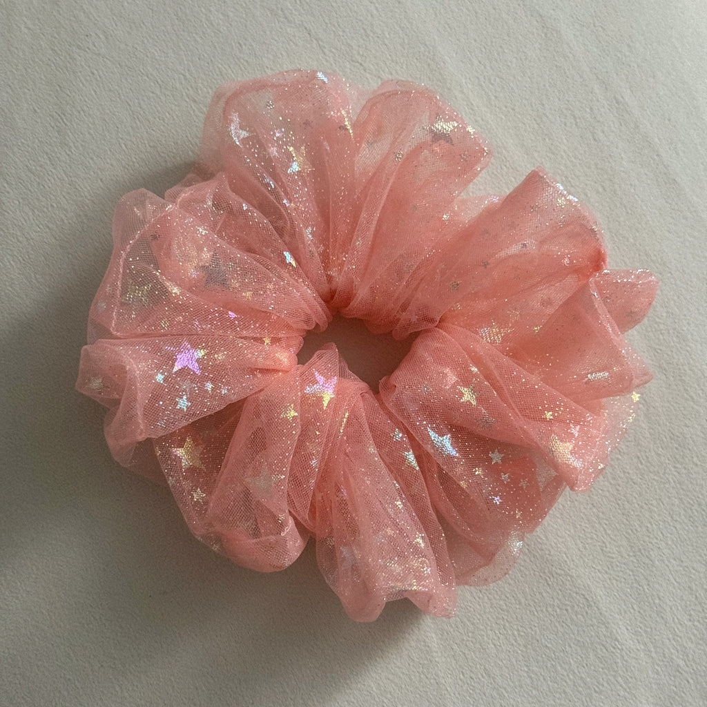 Pink glittery scrunchie on a light gray background
