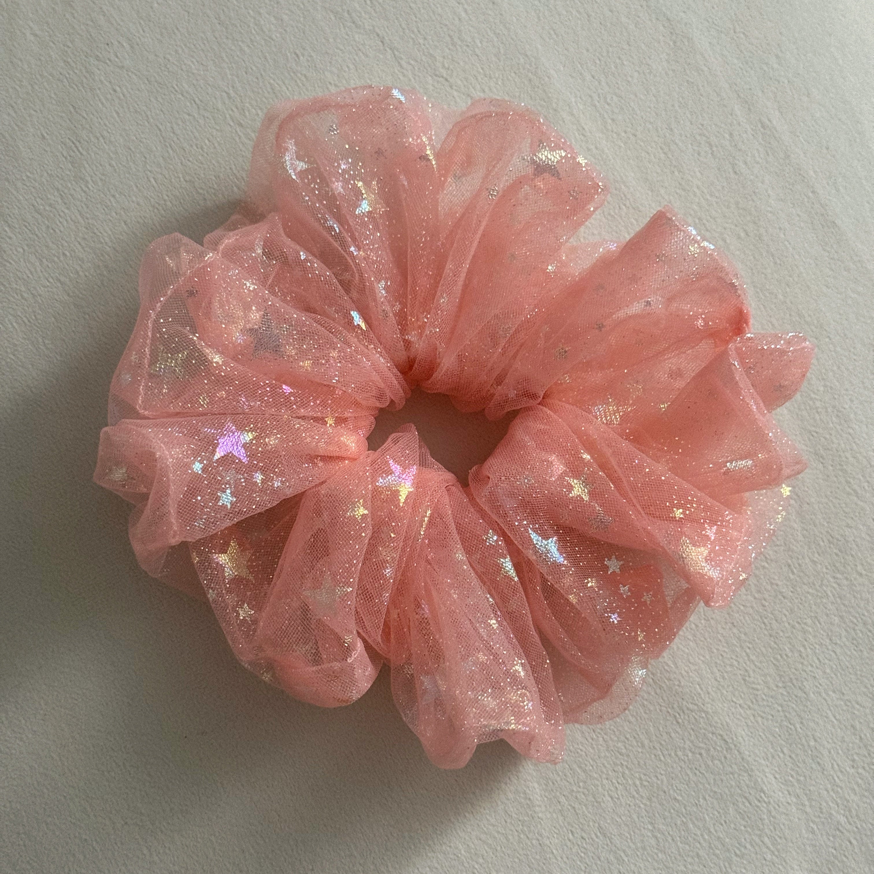 Pink glittery scrunchie on a light gray background