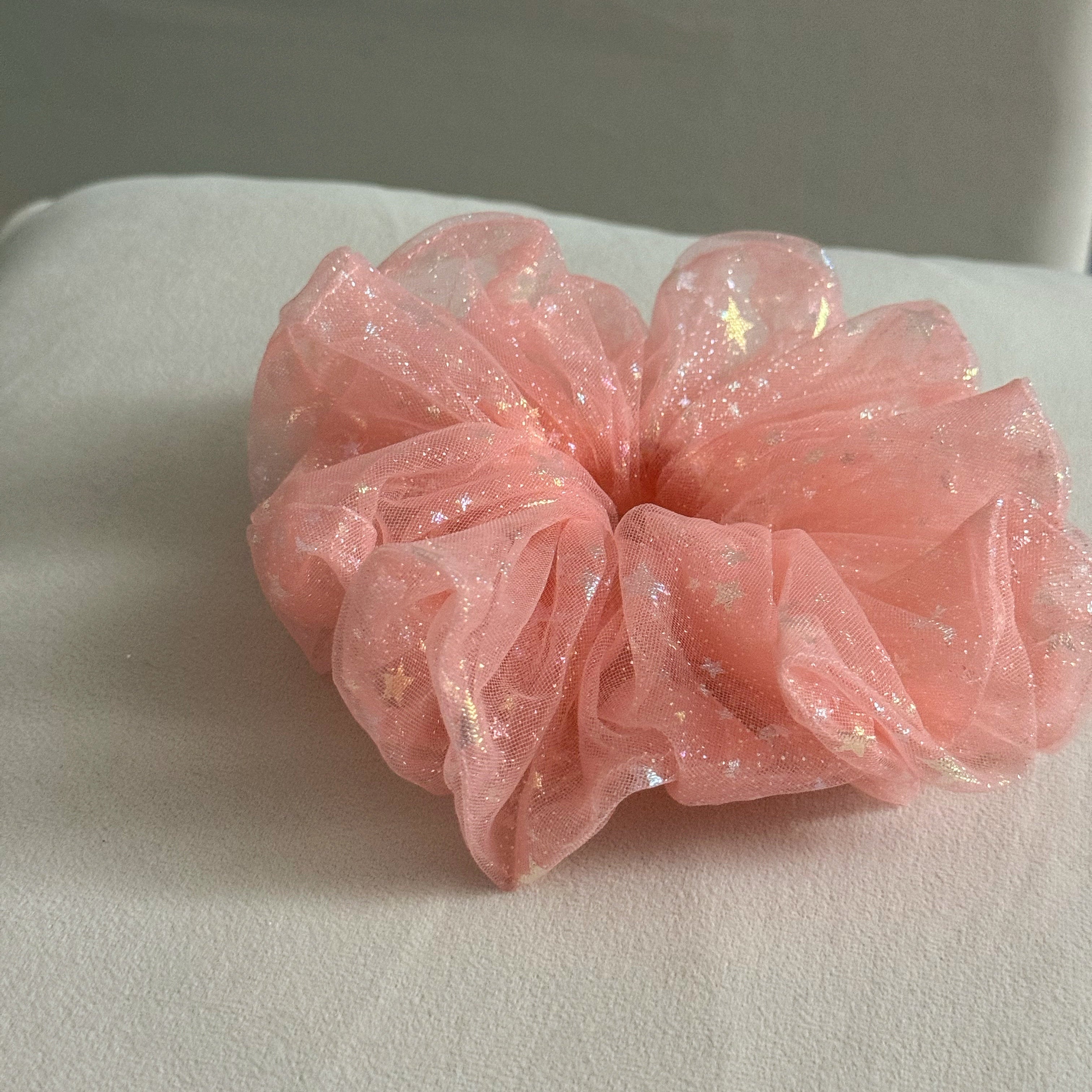Pink glittery scrunchie on a light gray surface