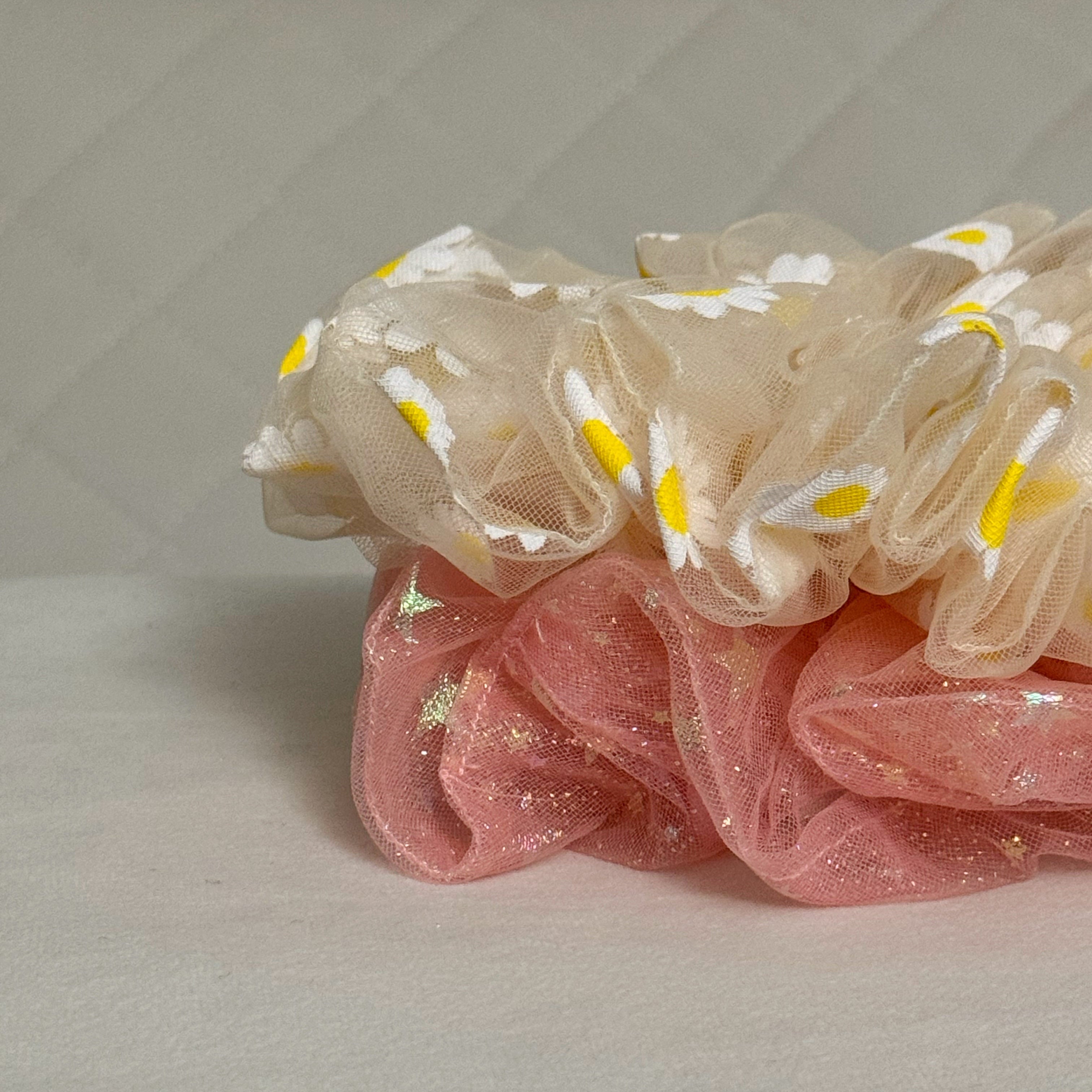 Scrunchies with pink and beige colors on a light gray background