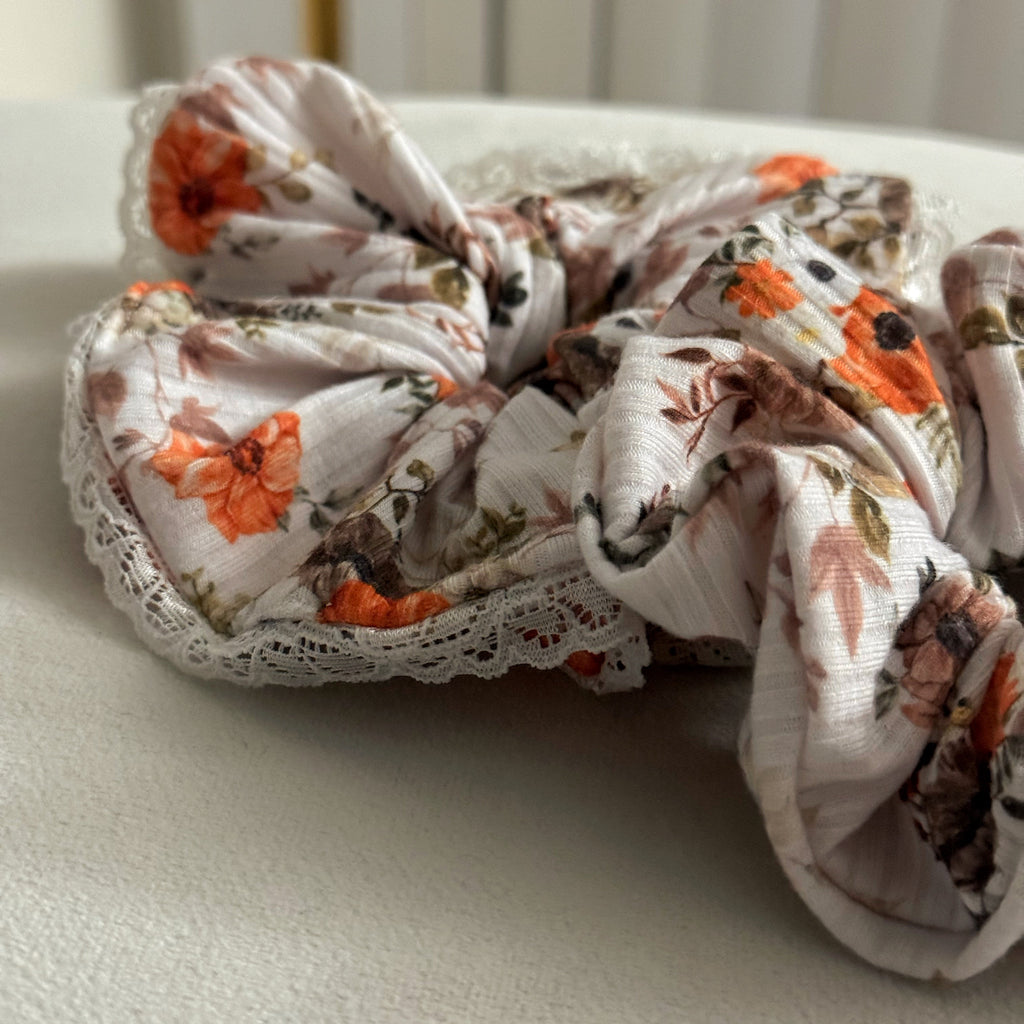 Floral scrunchie with lace details on a light surface