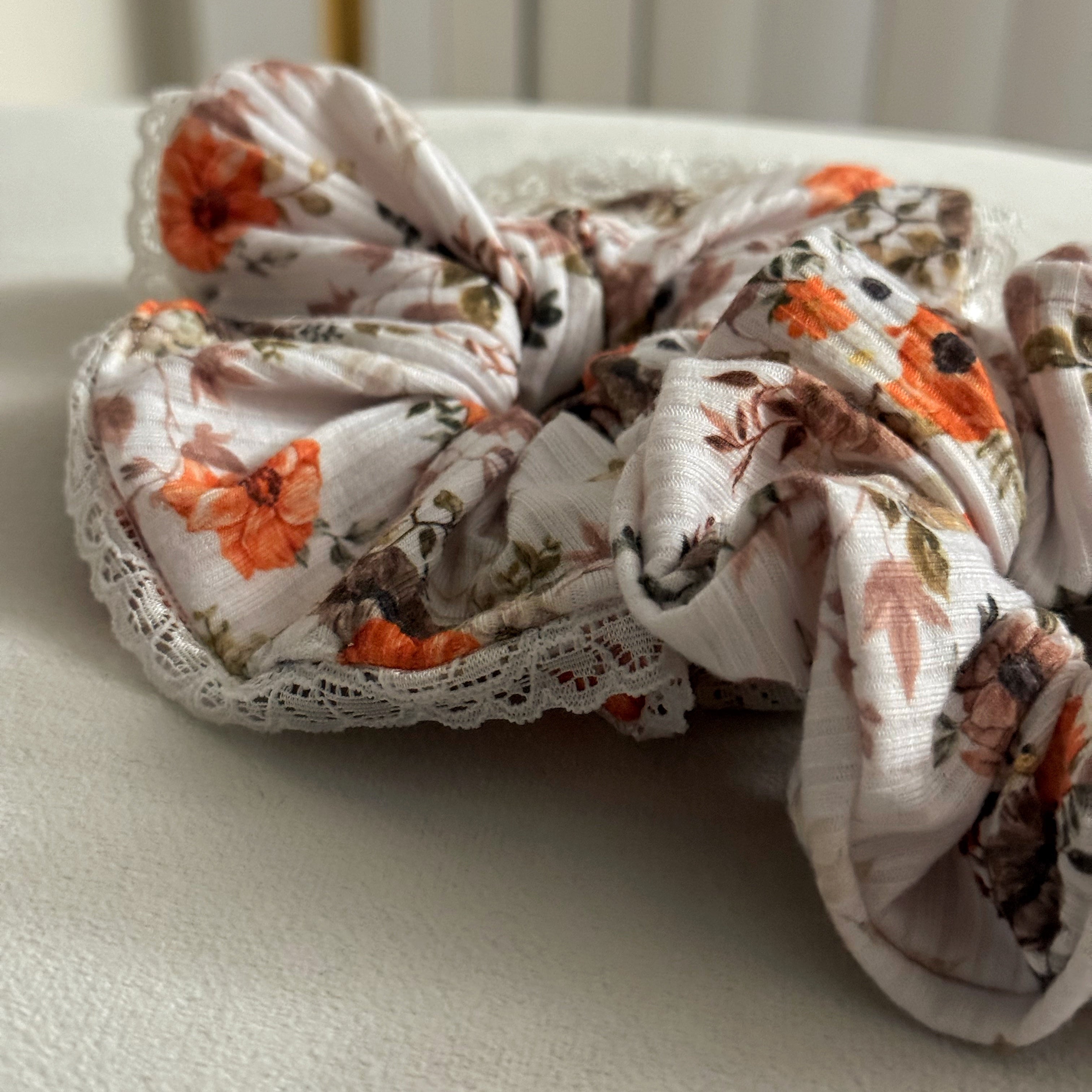Floral scrunchie with lace details on a light surface
