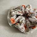 Floral scrunchie with lace edge on a light gray background
