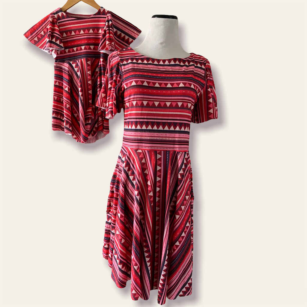 Red and black patterned dress on a mannequin against a white background