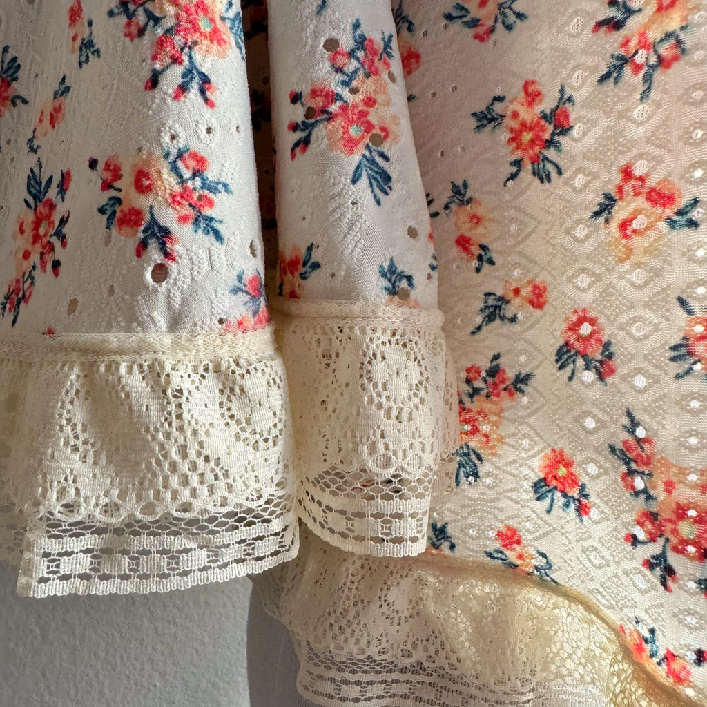 Floral lace fabric with a mannequin wearing a floral top.