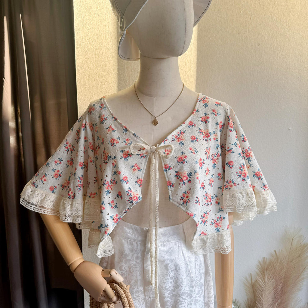 Mannequin wearing a floral blouse with a plain background