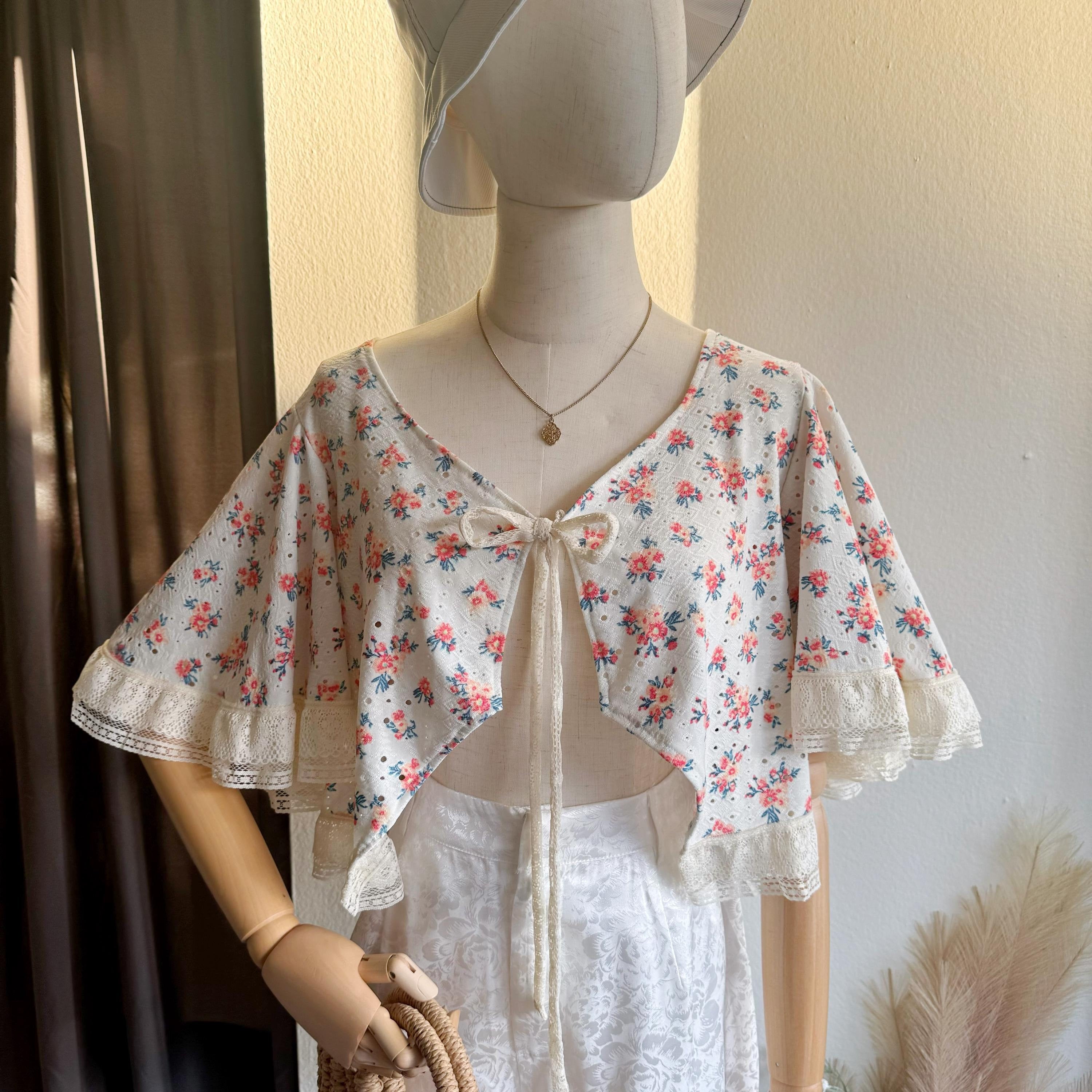 Mannequin wearing a floral blouse with a plain background