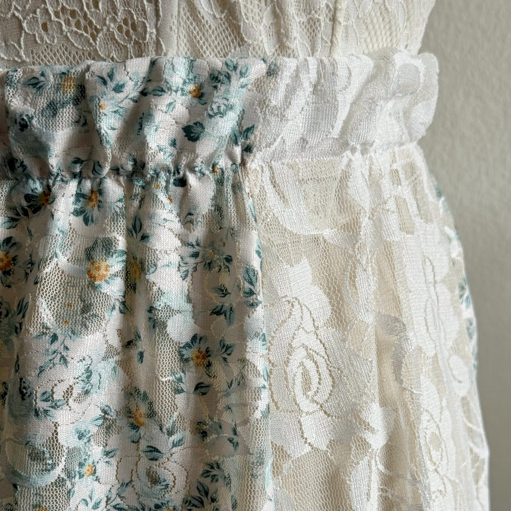 Close-up of a floral fabric and lace fabric against a neutral background