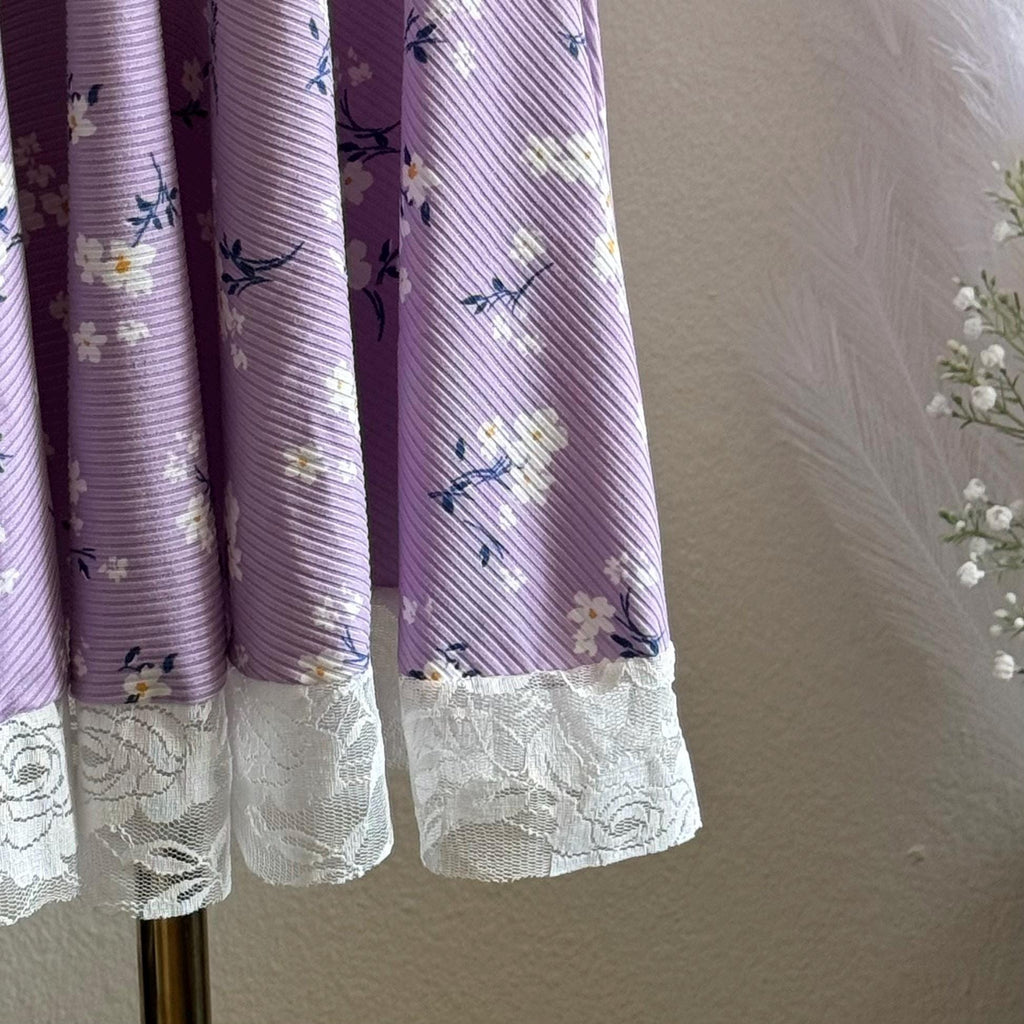 Purple dress with floral pattern and lace trim on a neutral background