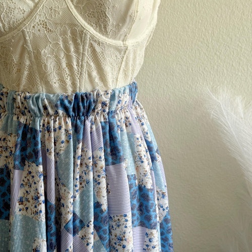 Lace top and floral skirt against a plain wall