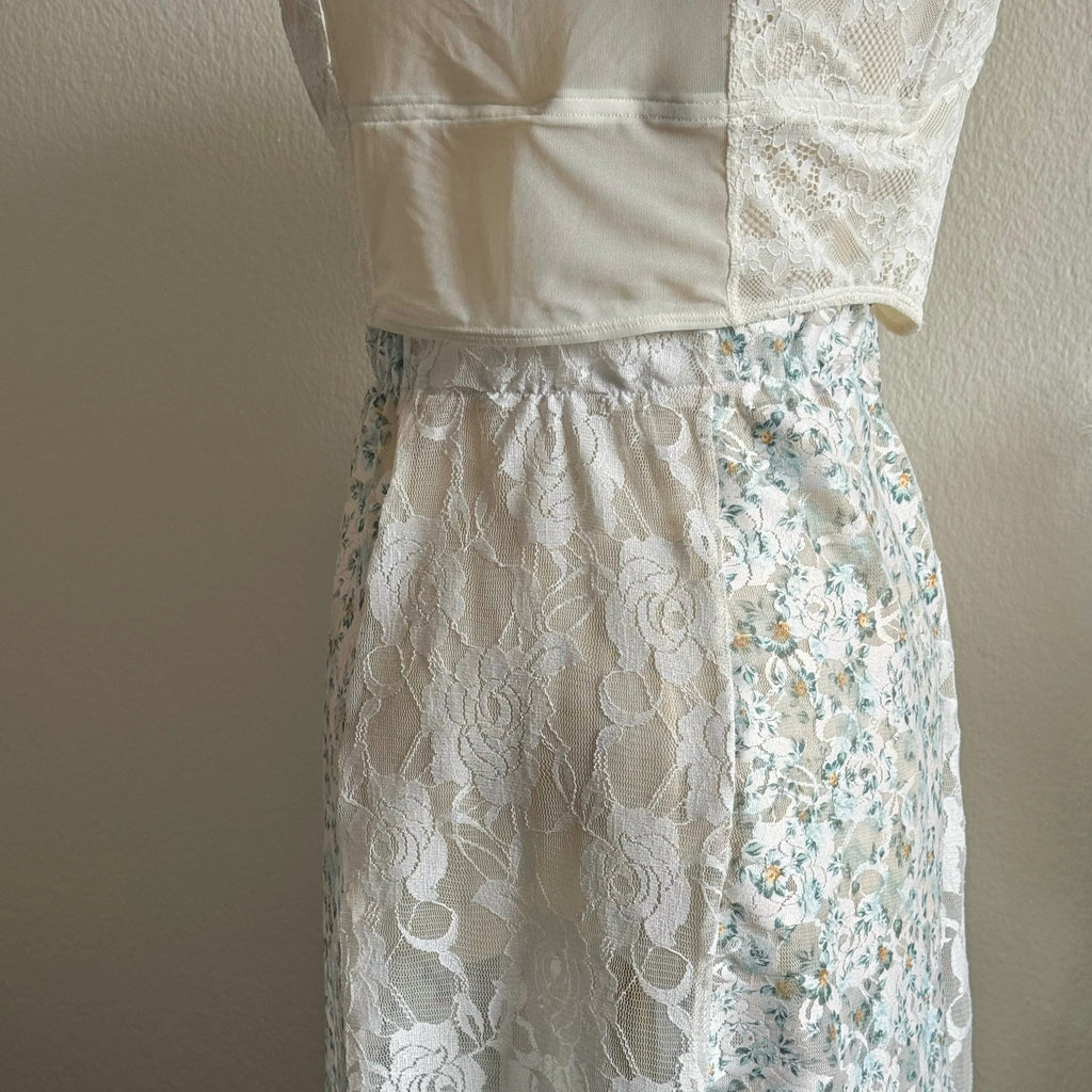 White lace top and floral skirt on a mannequin against a plain background