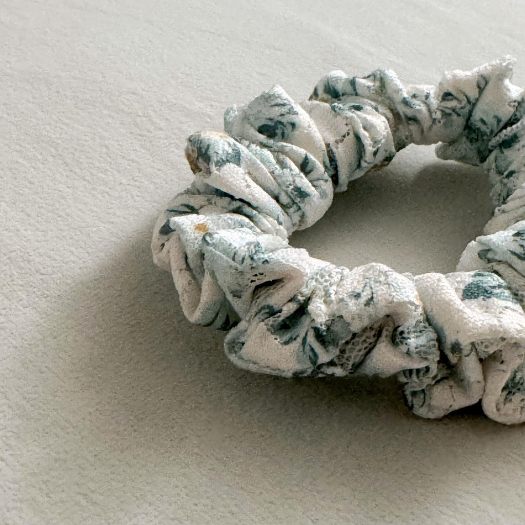 Floral patterned scrunchie on a textured surface