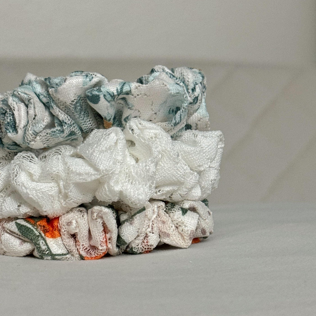 Stack of colorful fabric scrunchies on a light gray surface