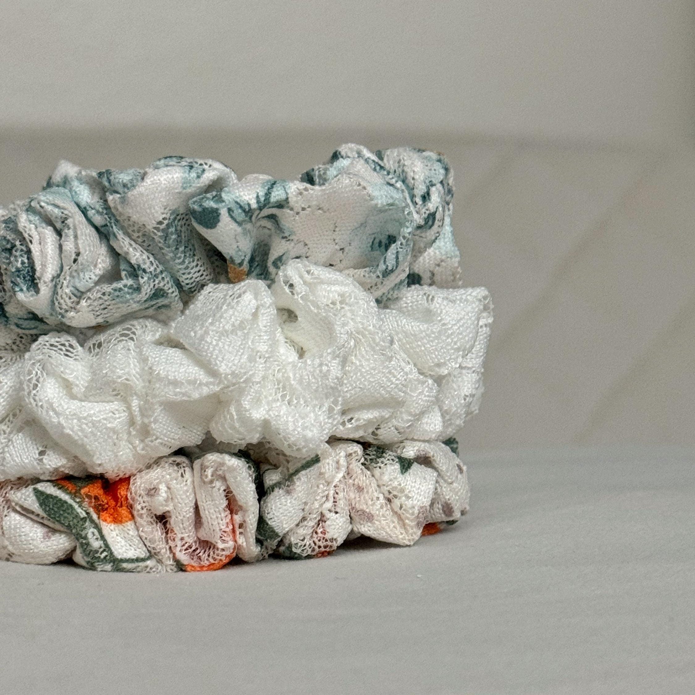 Stack of colorful fabric scrunchies on a light gray surface
